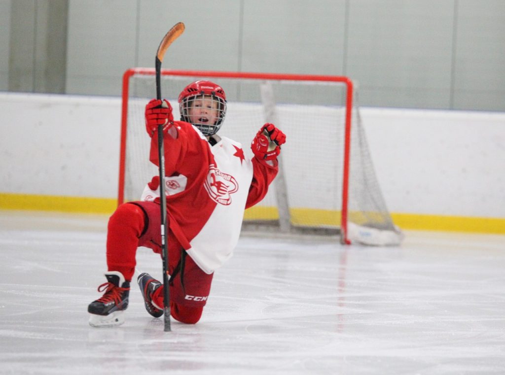 Jeune gardien de but heureux sur la glace